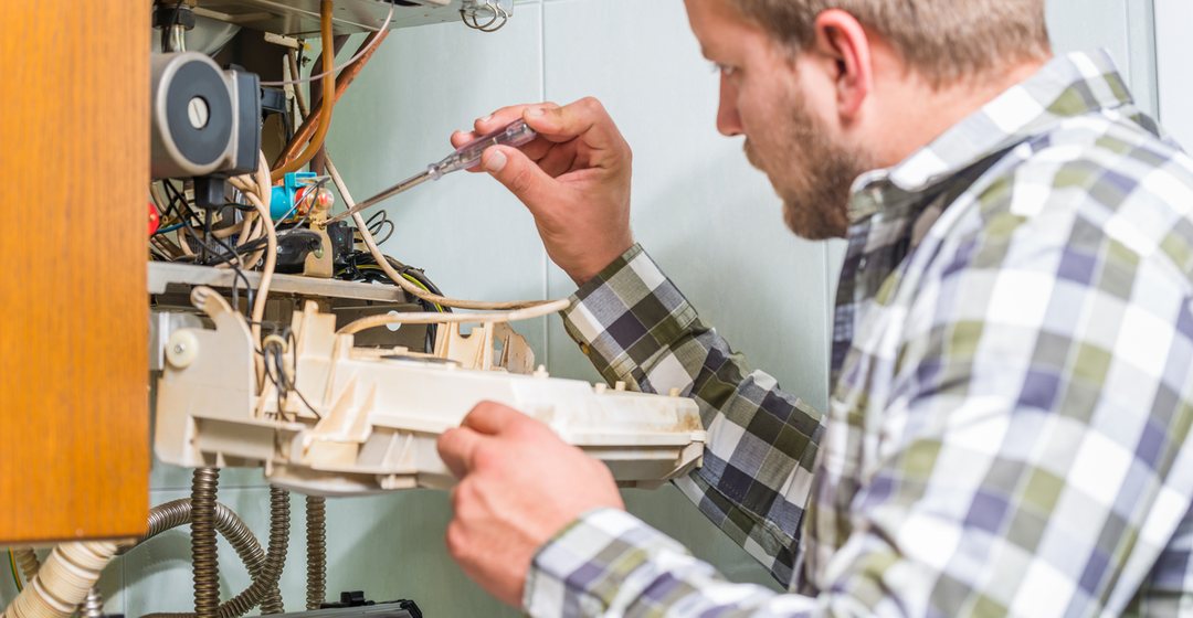 Technician testing a residential heating unit during an annual service visit
